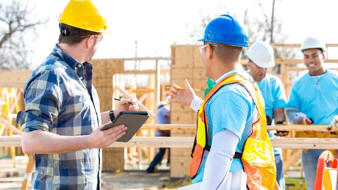 A family standing in front of their existing home, discussing the new construction