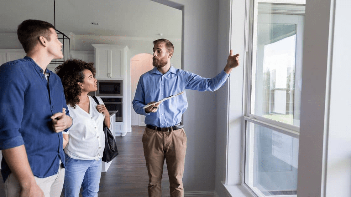 A real estate agent showing a house to a family