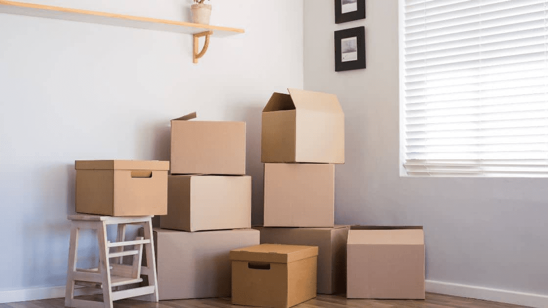 A photo of a newly renovated room with moving boxes in the corner, showcasing the process of moving and renovating to make the most of your new space.